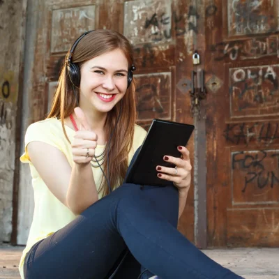 young-woman-with-a-tablet-and-headphones-holding-t-2023-11-27-05-22-29-utc